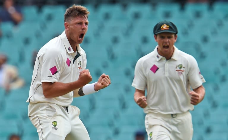 Australian paceman James Pattinson (L) celebrates with teammate Stephen O'Keefe (L) after dismissing West Indies batsman Carlos Brathwaite on the second day of the third Test in Sydney on January 4, 2016