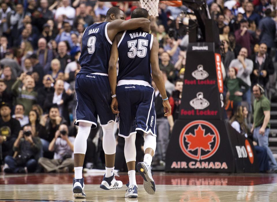 Oklahoma City Thunder forward Kevin Durant (35) is congratulated by teammate Serge Ibaka (9) after hitting a 3-point shot with 1.7 seconds left in the second overtime of an NBA basketball game agianst the Toronto Raptors in Toronto on Friday, March 21, 2014. The Thunder 119-118 in double overtime. (AP Photo/The Canadian Press, Nathan Denette)