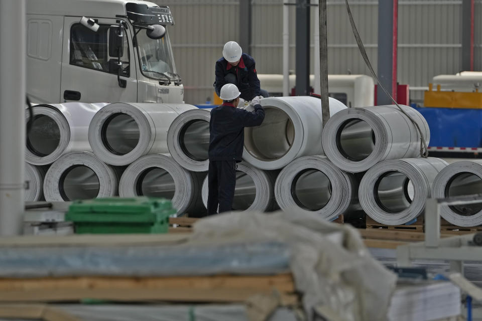 Workers check on the material for the Dongfeng truck at a manufacturing factory in Shiyan city in central China's Hubei Province on May 12, 2023. China's factory activity decelerated in May, a survey showed Wednesday, May 31 adding to signs its economic rebound after the end of anti-virus controls is slowing. (AP Photo/Andy Wong)