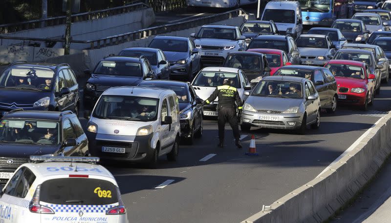 FILE PHOTO: A traffic policeman checks license plates during traffic restrictions intended to curb air pollution in Madrid