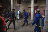In this in Wednesday, March 25, 2020 photo, volunteers disinfect an overcrowded housing complex to prevent the spread of coronavirus in Sale, near Rabat, Morocco. (AP Photo/Mosa'ab Elshamy)