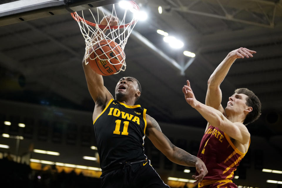 Iowa guard Tony Perkins (11) dunks the ball ahead of Iowa State guard Caleb Grill, right, during the second half of an NCAA college basketball game, Thursday, Dec. 8, 2022, in Iowa City, Iowa. (AP Photo/Charlie Neibergall)