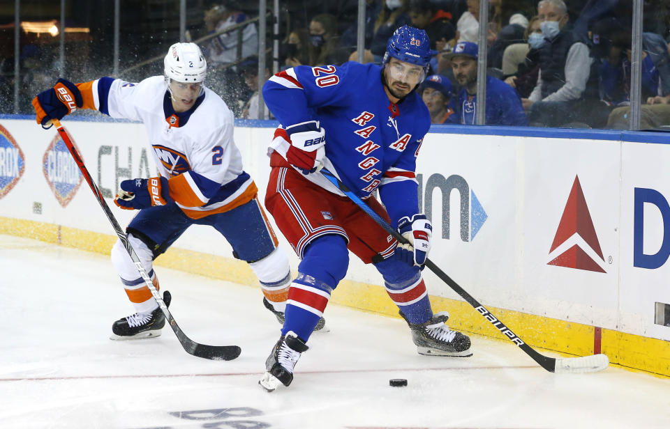 New York Rangers Chris Kreider (20) plays the puck against New York Islanders Thomas Hicky (2) during the second period of a preseason NHL hockey game, Sunday, Sept. 26, 2021, in New York. (AP Photo/Noah K. Murray)