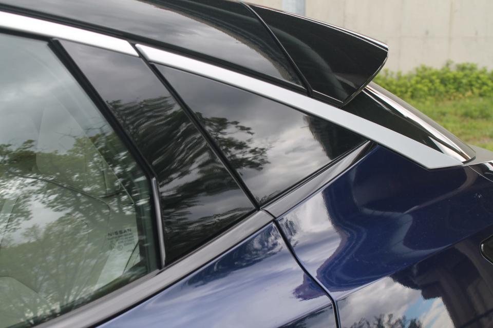 A close-up of the black and blue bodywork of the 2023 Nissan Ariya.