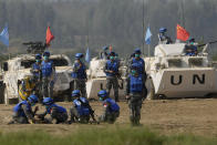 United Nations troop tend to a participant playing the role of injured civilian during a scenario where they pacify local civilians fighting over water resource during the Shared Destiny 2021 drill at the Queshan Peacekeeping Operation training base in Queshan County in central China's Henan province Wednesday, Sept. 15, 2021. Peacekeeping troops from China, Thailand, Mongolia and Pakistan took part in the 10 days long exercise that field reconnaissance, armed escort, response to terrorist attacks, medical evacuation and epidemic control. (AP Photo/Ng Han Guan)