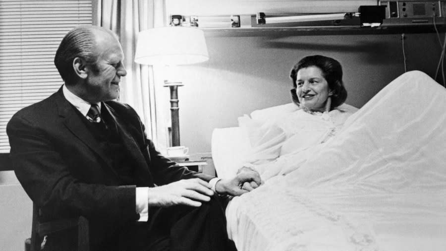 A 1974 photo shows President Gerald R. Ford holding hands with the First Lady while she recovers from breast cancer surgery at the Bethesda Naval Hospital. (Getty Images)