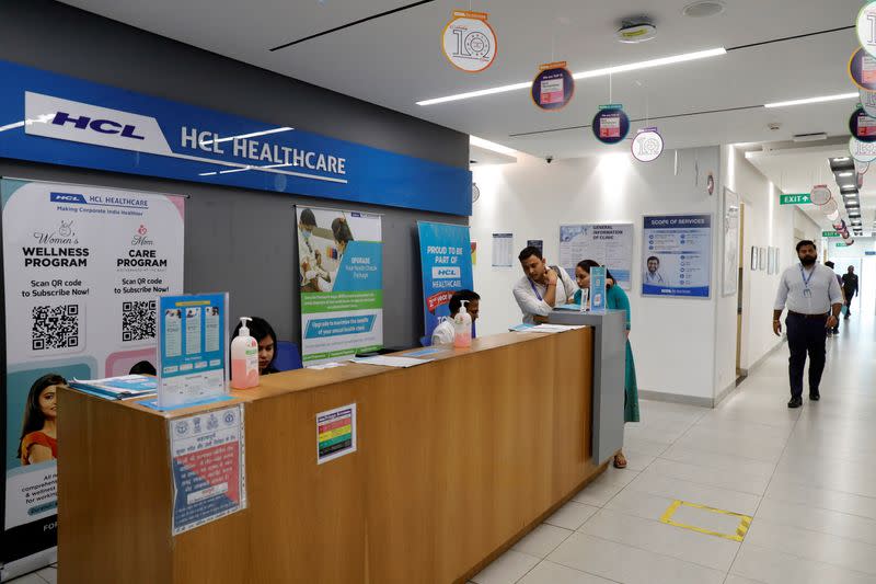 Employees stand at a front desk of healthcare section of HCLTech inside its office building on outskirts of Lucknow