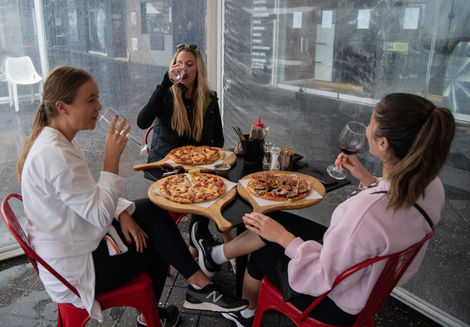 A group of women eating pizza and drinking wine at a restaurant in Bondi Beach, Sydney, on Friday. Source: AAP
