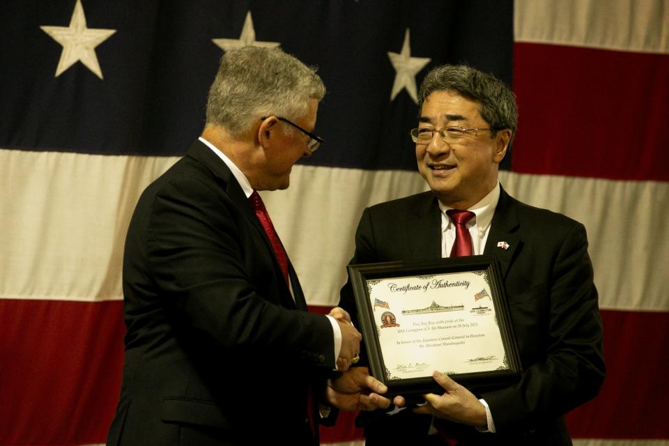 Steve Banta, executive director of the USS Lexington Museum on the Bay, shakes hands with Hirofumi Murabayashi, consul general of the Japanese Consul-General Office in Houston,  at the USS Lexington Museum on the Bay Thursday, July 20, 2023. Banta gifted Murabayashi with an American flag and a certificate of authenticity.