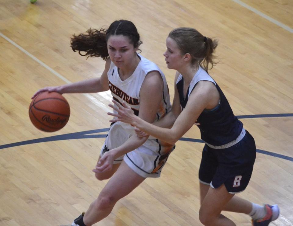 Cheboygan junior guard Kenzie Burt, left, drives past Boyne City's Elly Day during the first half of a varsity girls basketball contest in Cheboygan on Tuesday.