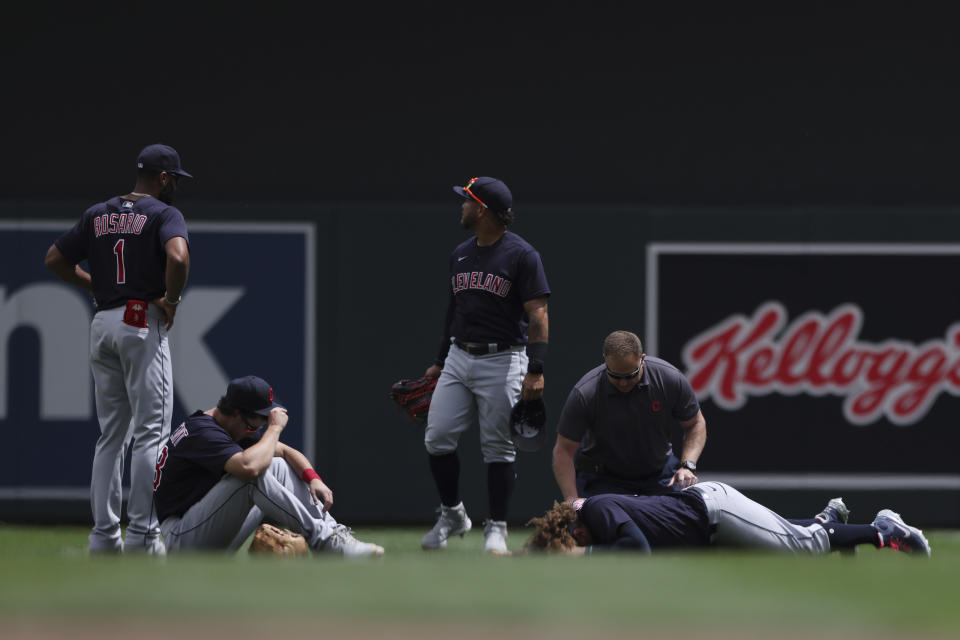 Cleveland Indians' Josh Naylor (22) lies on the ground with a member from the Indians medical staff after colliding with teammate Ernie Clement to catch a ball during the fourth inning of a baseball game against the Minnesota Twins, Sunday, June 27, 2021, in Minneapolis. (AP Photo/Stacy Bengs)
