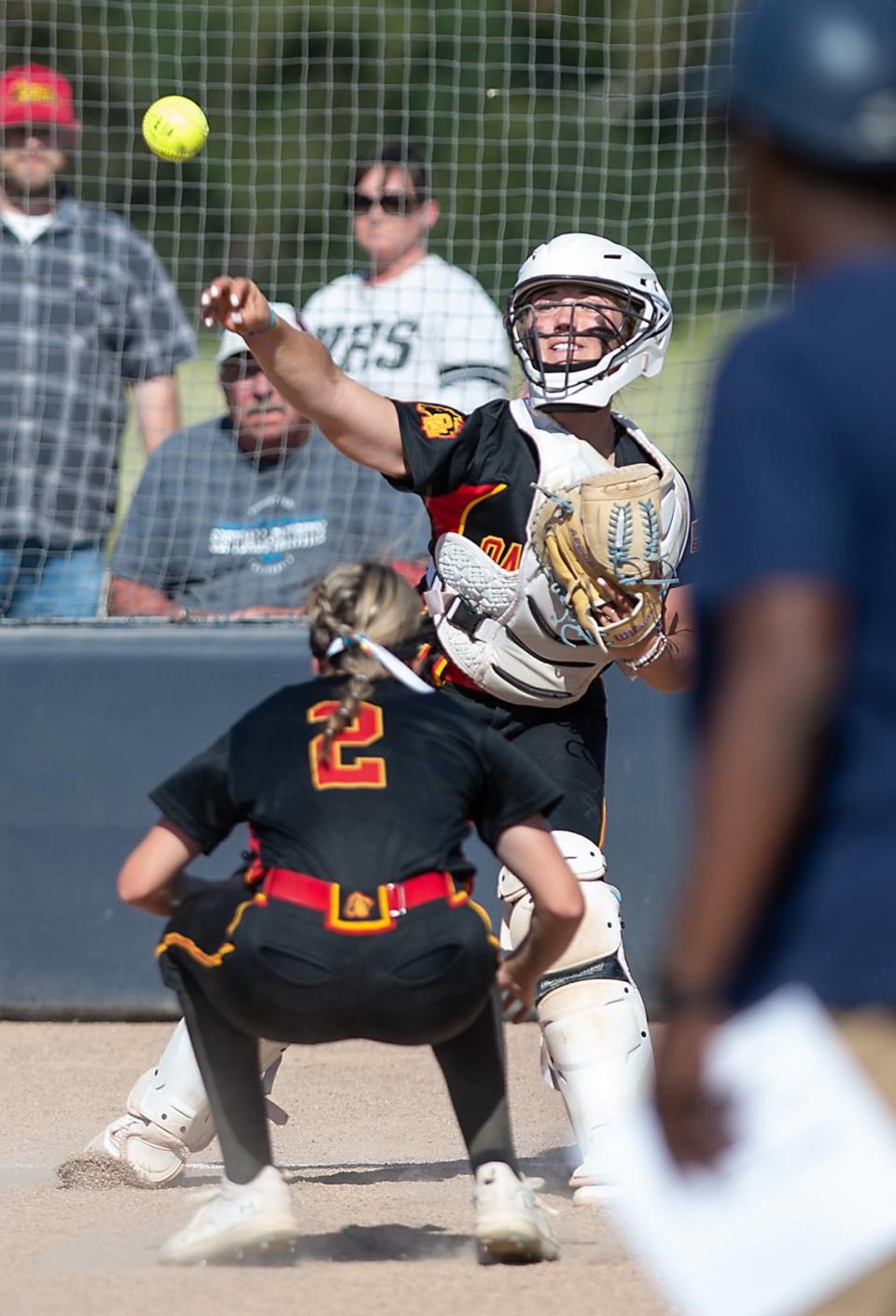 Oakdale catcher Presley Barnes attempts to throw out a runner at third base during the Valley Oak League game with Central Catholic at Central Catholic High School in Modesto, Calif., Tuesday, April 25, 2023.