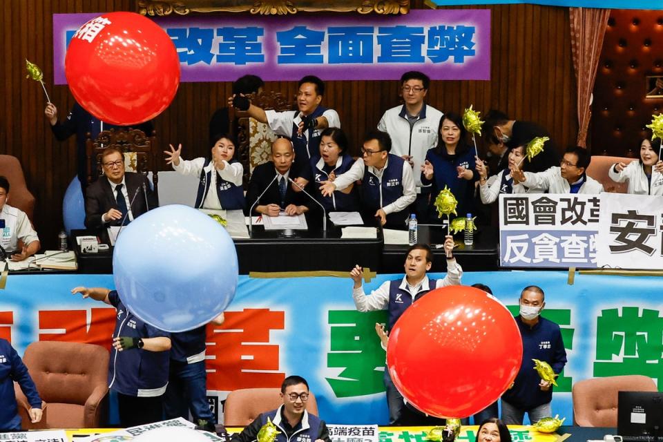 Taiwanese lawmakers from the Democratic Progressive Party throw inflatable balloons with words reading 'anti evil laws' at the Parliament President Han Kuo-yu (EPA)