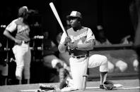 FILE - Atlanta Braves' right-handed slugger Hank Aaron (44) kneels in the batting circle as he waits for his turn at bat in a baseball game against the Cincinnati Reds at Riverfront Stadium in Cincinnati, Ohio, in this April 4, 1974, file photo. During the game Aaron tied the all-time home run record at 714. (AP Photo/File)