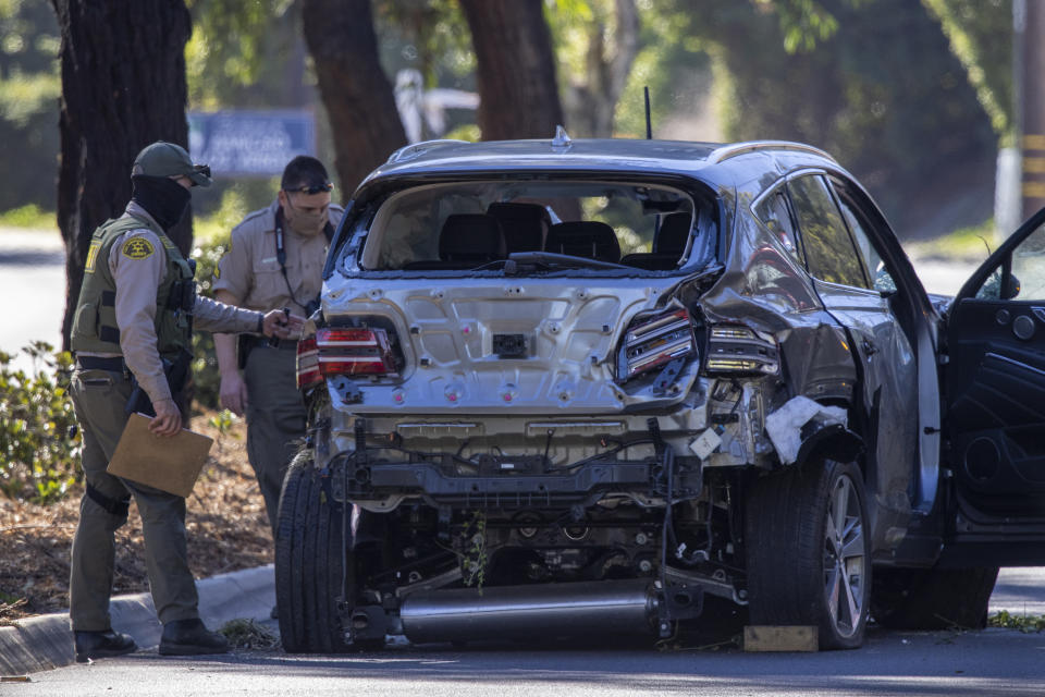 Los Angeles County Sheriff deputies gather evidence from the car that golf legend Tiger Woods was driving when seriously injured in a rollover accident on February 23, 2021 in Rolling Hills Estates, California.