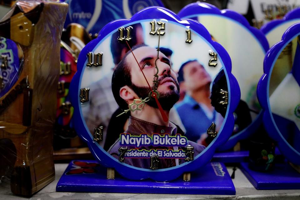 A round, purple-framed clock with an image of a bearded man looking up