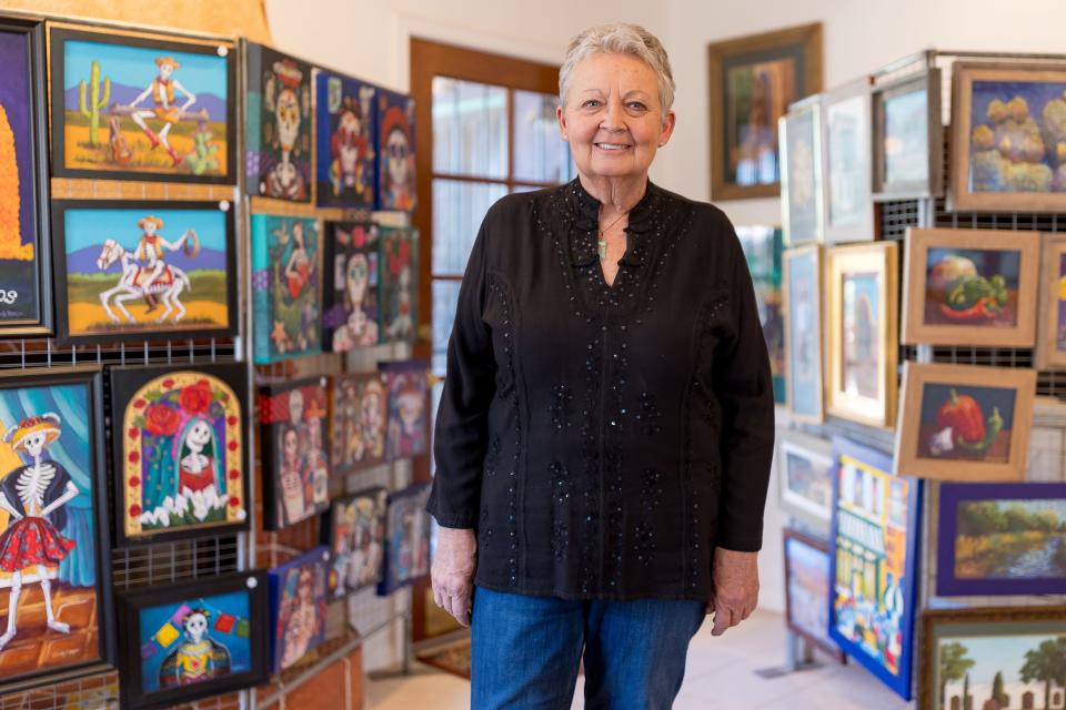Artist Candy Mayer stands by her paintings at her home in West El Paso on Tuesday, May 23, 2023, for a portrait. Mayer is having an art and moving sale on May 26-28 as she is moving from El Paso.