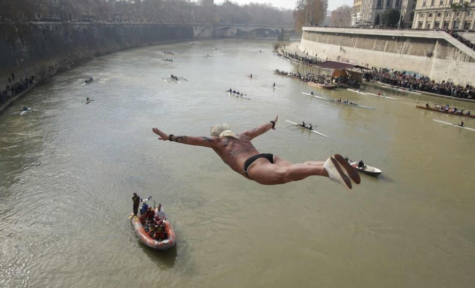 Maurizio Palmulli of Italy dives into the Tiber River from the Cavour bridge, as part of traditional New Year celebrations January 1, 2013. Four men dived the muddy waters of the Tiber from the Cavour bridge, continuing an annual tradition which dates back to 1946.