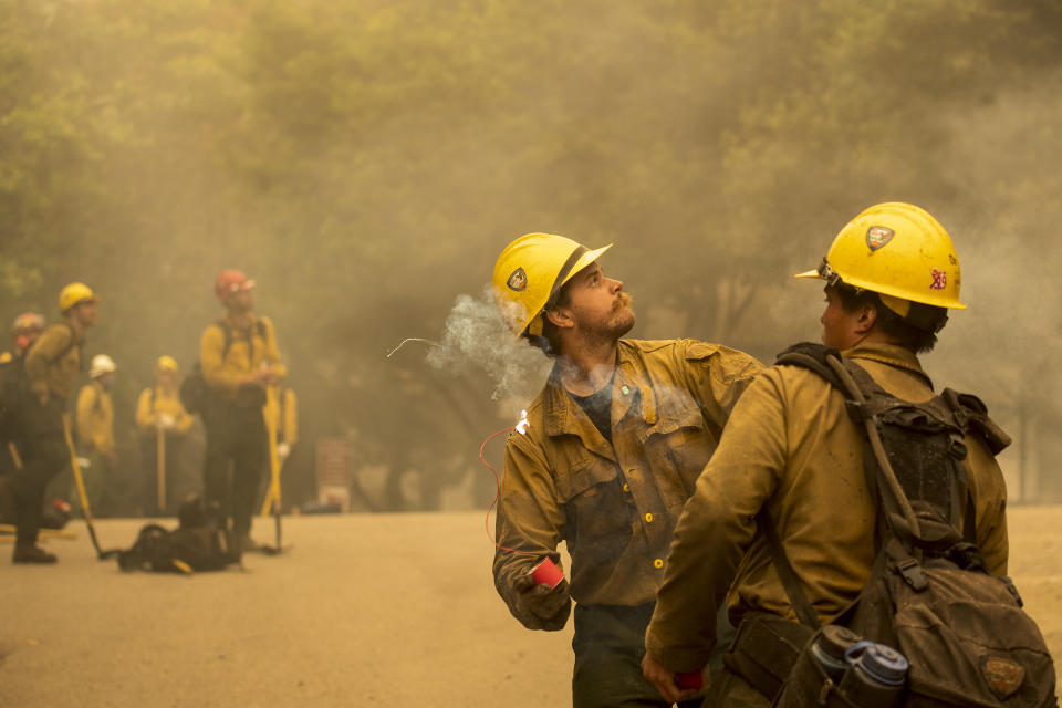 Max Blanton, a firefighter with Vandenberg Air Force Base, prepares to throw an incendiary device during a back burn to help control the Dolan Fire at Limekiln State Park in Big Sur, Calif,. Friday, Sept. 11, 2020. (AP Photo/Nic Coury)