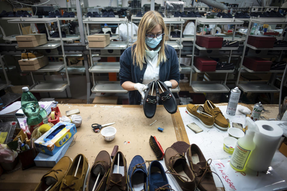 Workers of the Calzaturificio M.G.T shoe factory in Castelnuovo Vomano, central Italy, return to work, Monday, May 4, 2020. Italy began stirring again Monday after a two-month coronavirus shutdown, with 4.4 million Italians able to return to work and restrictions on movement eased in the first European country to lock down in a bid to stem COVID-19 infections. (AP Photo/Domenico Stinellis)