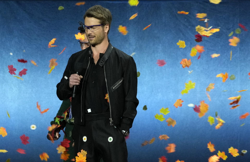 Glen Powell, a cast member in the upcoming film "Twisters," faces flying leaves from a wind machine onstage during the Universal Pictures and Focus Features presentation at CinemaCon 2024, Wednesday, April 10, 2024, at Caesars Palace in Las Vegas. (AP Photo/Chris Pizzello)