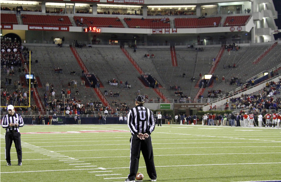 FIUE - In this Nov. 19, 2011, file photo, empty seats are seen in the student section of Vaught-Hemingway Stadium as umpire Rick Lowe waits for LSU and Mississippi players to return to the field during a time out in the fourth quarter of their NCAA college football game in Oxford, Miss. As lock-downs are lifted, restrictions on social gatherings eased and life begins to resemble some sense, sports are finally starting to emerge from the coronavirus pandemic. Many college and pro sports teams already were dealing with declining ticket sales. (AP Photo/Rogelio V. Solis, File)