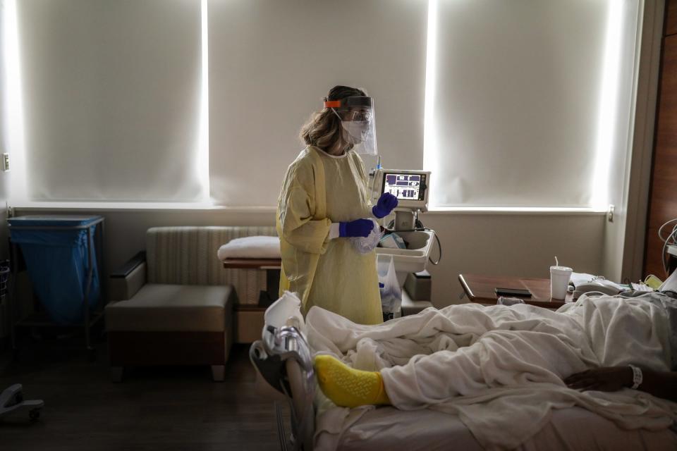 Respiratory therapist Eralda Bendaj, 31, of Wixom, talks with a COVID-19 patient as she performs a home oxygen study to check his blood oxygen levels to see whether he will need oxygen once he is discharged from Beaumont Hospital in Farmington Hills, Mich. on Dec. 17, 2020.