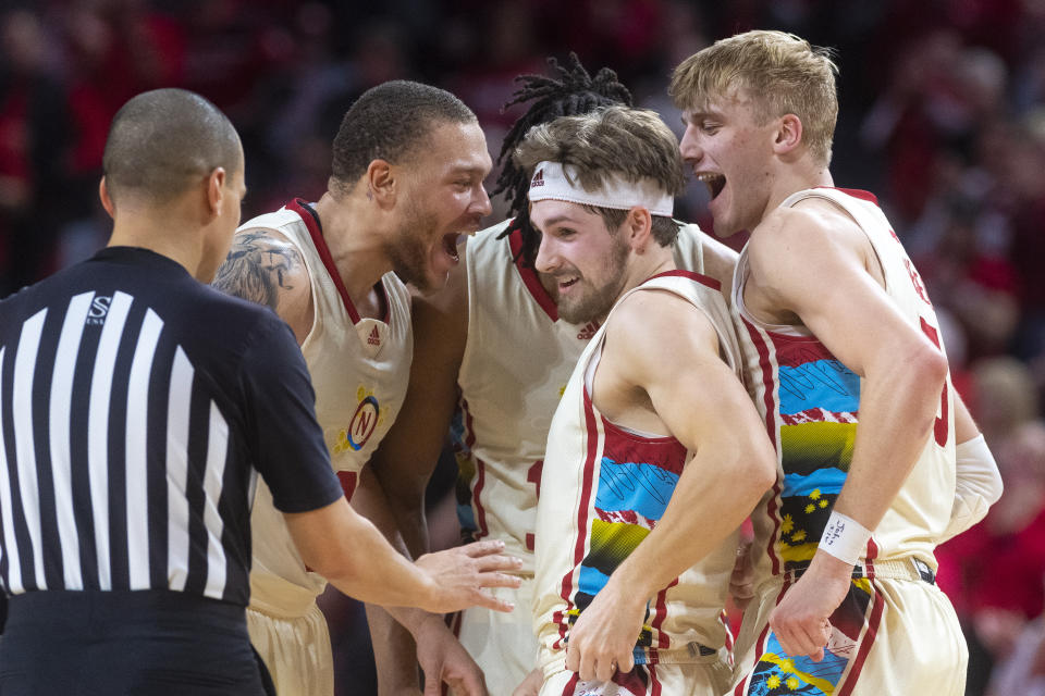 Nebraska's Sam Hoiberg, center, is helped up by his team after hustling after a loose ball the second half of an NCAA college basketball game against Minnesota, Saturday, Feb. 25, 2023, at Pinnacle Bank Arena in Lincoln, Neb. (Kenneth Ferriera/Lincoln Journal Star via AP)