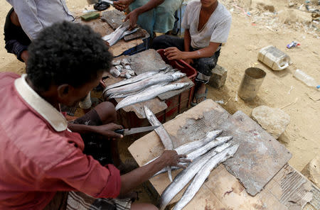 Vendors clean fish at a market near the village of al-Jaraib, in the northwestern province of Hajjah, Yemen, February 20, 2019. REUTERS/Khaled Abdullah