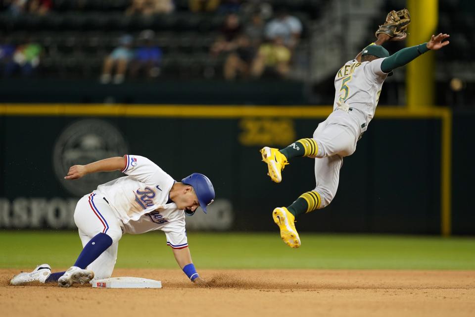 Texas Rangers' Mark Mathias steals second as Oakland Athletics second baseman Tony Kemp leaps to catch the high throw to the bag in the seventh inning of a baseball game in Arlington, Texas, Wednesday, Sept. 14, 2022. (AP Photo/Tony Gutierrez)