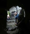 A government soldier looks out from a partially destroyed wall of a house, caused by fighting between government soldiers and Muslim rebels from the Moro National Liberation Front (MNLF), in Zamboanga city in southern Philippines September 15, 2013. (REUTERS/Erik De Castro)