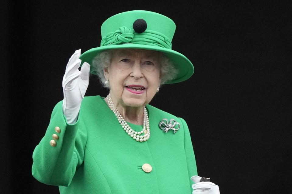 ARCHIVO - La reina Isabel II saluda a la multitud durante el desfile de su Jubileo de Platino en el Palacio de Buckingham en Londres el 5 de junio de 2022, en el último diá de celebraciones por el jubileo. La reina Isabel II, la monarca con el reinado más largo de Gran Bretaña y una roca de estabilidad durante la mayor parte de un siglo turbulento, falleció el jueves 8 de septiembre de 2022 después de 70 años en el trono, informó el Palacio de Buckingham. Tenía 96 años. (AP Photo/Frank Augstein, File)