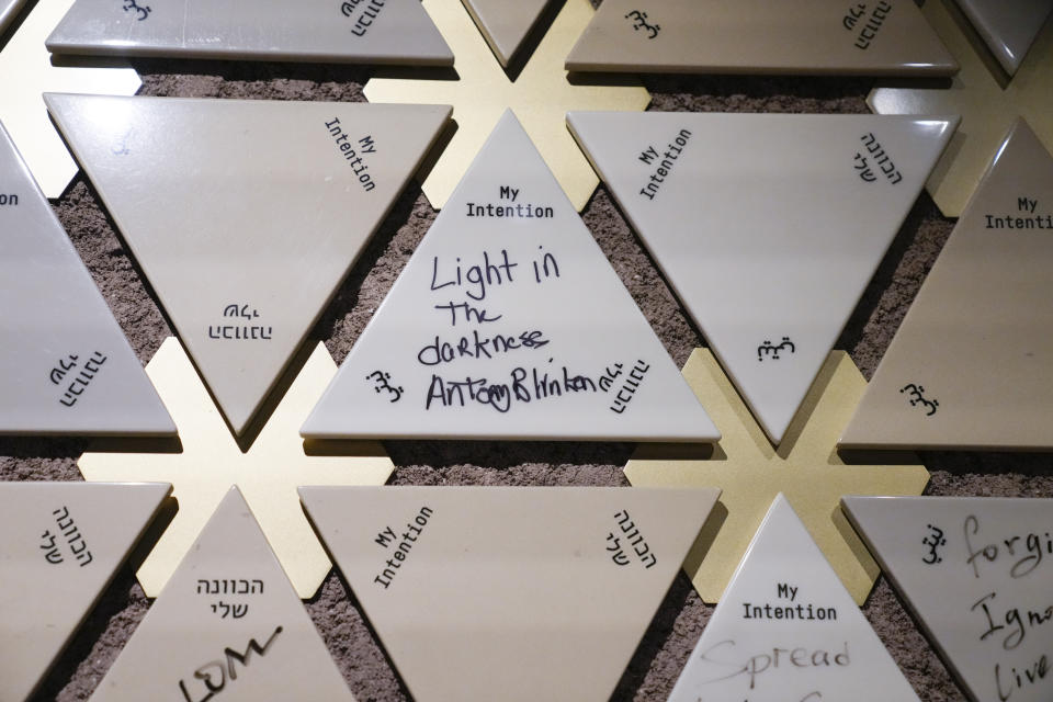 A tile signed by U.S. Secretary of State Antony Blinken is displayed on the intention wall at the Abrahamic Family House, in Abu Dhabi, United Arab Emirates, Saturday Oct. 14, 2023. Blinken wrote "Light in the darkness" on the tile before placing it on the wall. (AP Photo/Jacquelyn Martin, Pool)