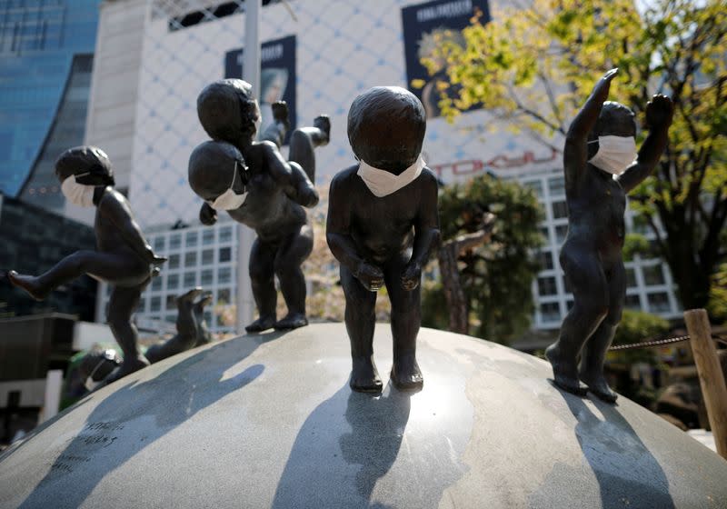 Statues wearing protective face masks are seen after the government announced the state of emergency for the capital following the coronavirus disease outbreak, at Shibuya shopping and entertainment district in Tokyo