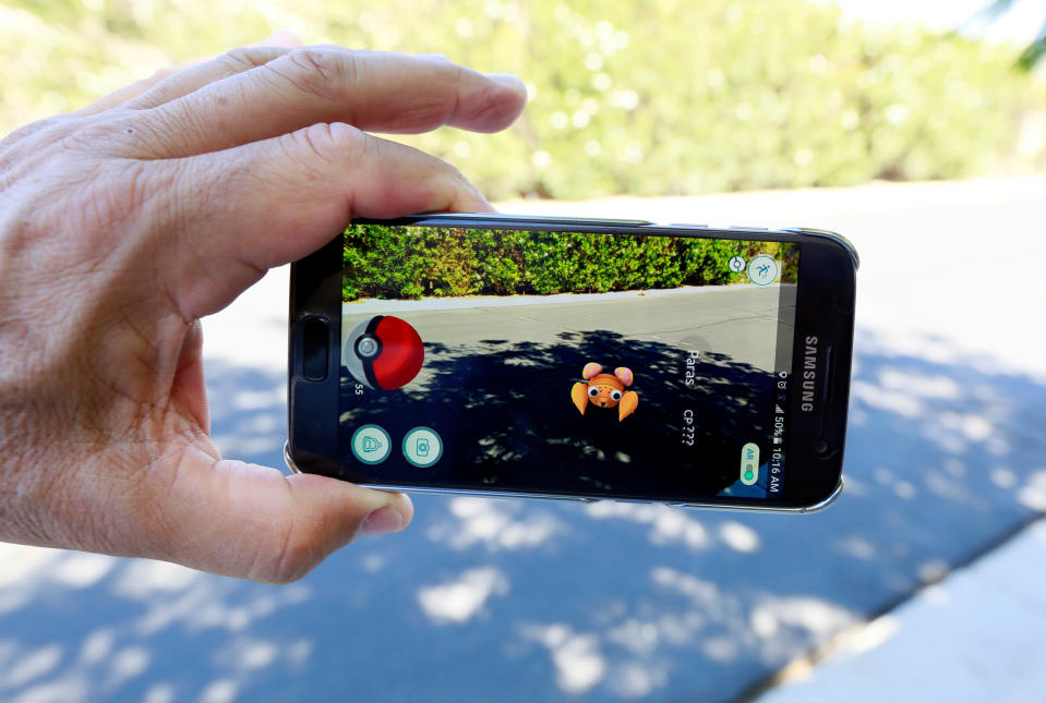 A person plays Pokémon Go on his cell phone in Palm Springs, California.  (Reuters)