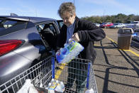 Sybil Smith, 75, a retired south Jackson, Miss., resident, loads packages of water into her vehicle, Wednesday, Jan. 26, 2022. Smith and her husband have weathered the city's low water pressure at home for extended periods and are concerned about its drinking quality. In addition to these packages of eight-ounce bottles, they also have six cases of pint sized bottles ready for use. (AP Photo/Rogelio V. Solis)