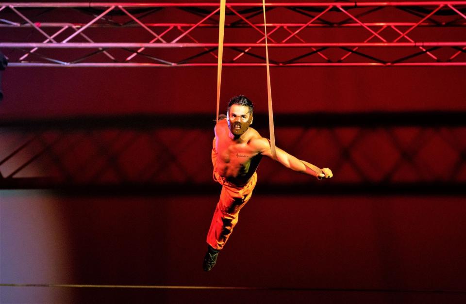 A flying cannibal hangs from aerial straps during a Paranormal Cirque show.