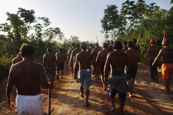 Indigenous people from the Kuruaia and Xipaia tribes march during a ceremony honoring the Xingu River before the start of the Xingu  23 event that gathers resisters of the Belo Monte dam project in the Amazon basin on June 13, 2012 in Santo Antonio, near Altamira, Brazil. Santo Antonio is adjacent to where the Belo Monte dam complex is under construction and the entire community will be expropriated for the construction. Around 60 families originally lived in Santo Antonio but now only about ten families remain.