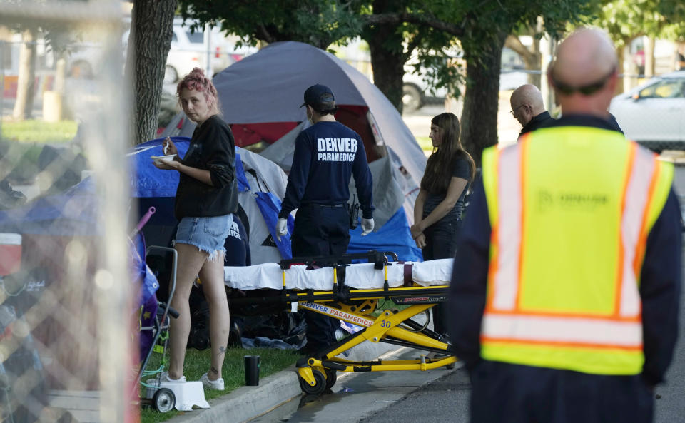 A city-sponsored sweep is carried out on an encampment of individuals living along Grant Street at Sixth Avenue south of downtown Denver on Wednesday, July 7, 2021. (AP Photo/David Zalubowski)