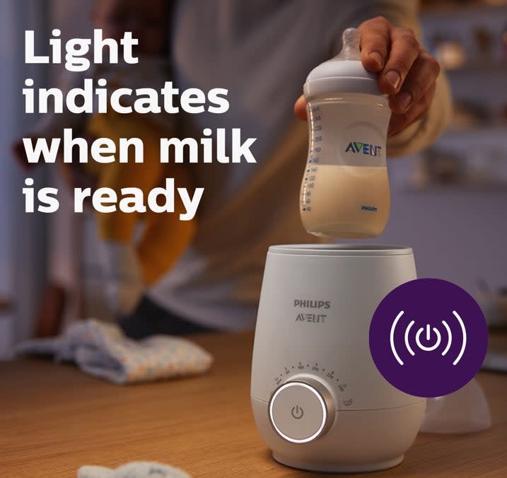 Person preparing a baby bottle with a Philips Avent bottle warmer; text explains light indicator and usage