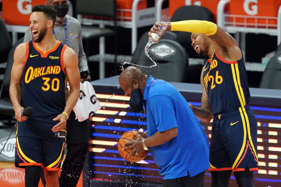 Golden State Warriors forward Kent Bazemore (26) pours water on guest public address announcer Aaron Taylor as guard Stephen Curry (30) laughs after the game against the Houston Rockets at Chase Center.