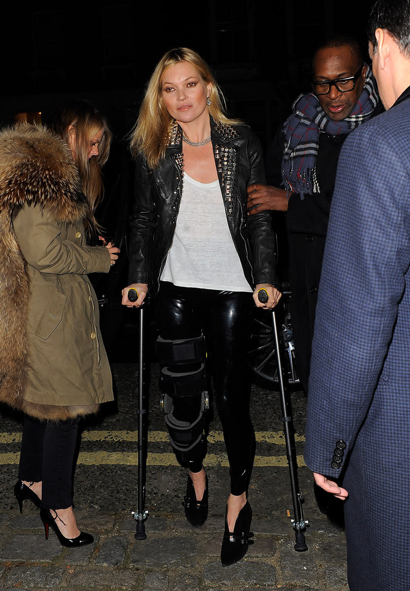 Kate Moss makes a grand entrance in a brace, crutches, and heels