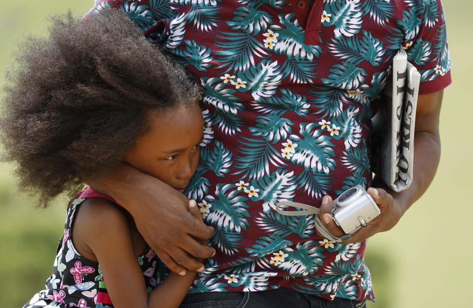 A girl looks on as former South African President Nelson Mandela's coffin is taken to the family gravesite for burial at his ancestral village of Qunu in the Eastern Cape province, 900 km (559 miles) south of Johannesburg, December 15, 2013. REUTERS/Siphiwe Sibeko (SOUTH AFRICA - Tags: OBITUARY POLITICS)