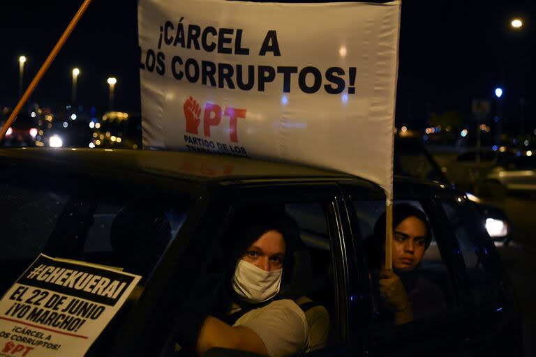 Manifestantes sostienen un cartel que dice 