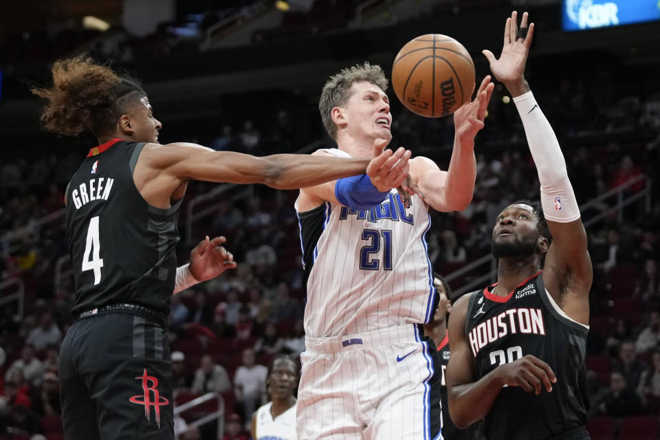 Orlando Magic center Moritz Wagner (21) is fouled by Houston Rockets guard Jalen Green (4) as center Bruno Fernando, right, helps defend during the first half of an NBA basketball game Wednesday, Dec. 21, 2022, in Houston. (AP Photo/Eric Christian Smith)