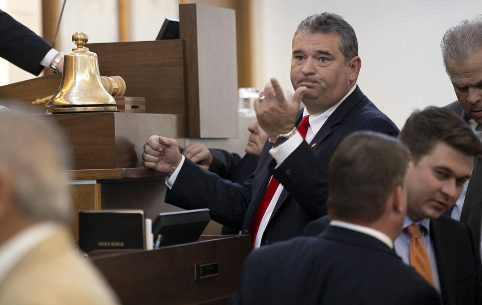 FILE - Rep. David Lewis huddles with fellow House members and House Speaker Tim Moore prior to the afternoon session of the House, Wednesday, Sept. 11, 2019, in Raleigh, N.C. The former North Carolina state lawmaker was sentenced Tuesday, Aug. 17, 2021 to probation and ordered to pay a fine for an unlawful scheme to siphon campaign dollars to his family farm. David Lewis, the former chairman of the powerful House Rules Committee and author of Republican redistricting plans during the 2010s, had pleaded guilty to two counts nearly a year ago. He resigned from the General Assembly the same day the accusations and the plea agreement became public. (Robert Willett/The News & Observer via AP)