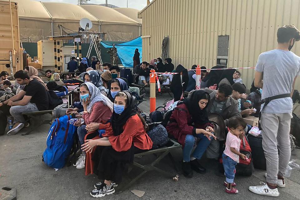 People wait to be evacuated from Afghanistan at the airport in Kabul on August 18, 2021 following the Taliban stunning takeover of the country. (Photo by - / AFP) (Photo by -/AFP via Getty Images)