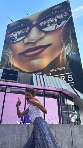 <p>Zendaya/Instagram</p> Zendaya posing with her thumbs up in front of a 'Challengers' billboard