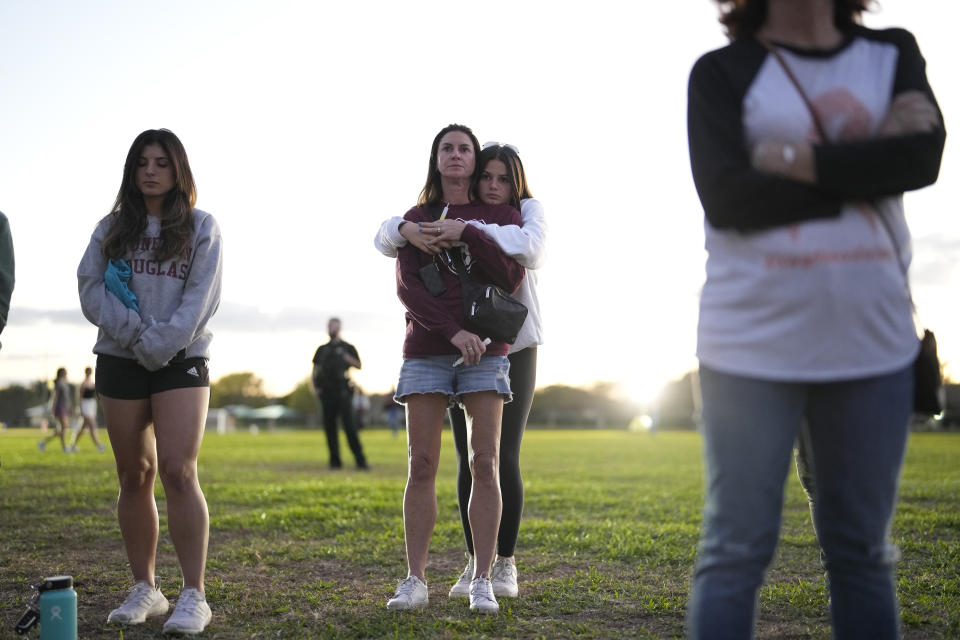 People embrace during a community commemoration ceremony for the 17 students and staff of Marjory Stoneman Douglas High School who were killed at the Parkland, Fla., school, on the five-year anniversary of the shooting, Tuesday, Feb. 14, 2023, at Pine Trails Park in Parkland. Family members, neighbors and well wishers turned out to multiple events Tuesday to honor the lives of those killed on Valentine's Day 2018. (AP Photo/Rebecca Blackwell)
