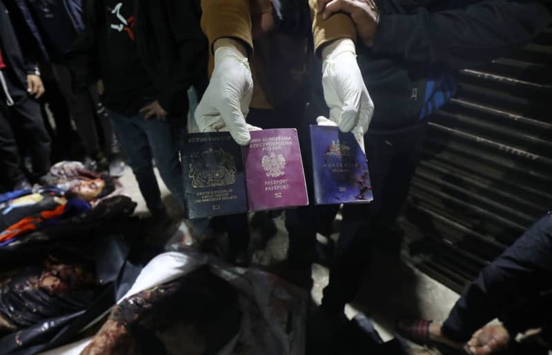 A person holds the passports belonging to deceased officials of the US-based international volunteer aid organization World Central Kitchen (WCK), following an Israeli attack on a WCK vehicle in Deir Al-Balah. Omar Ashtawy/APA Images via ZUMA Press Wire/dpa